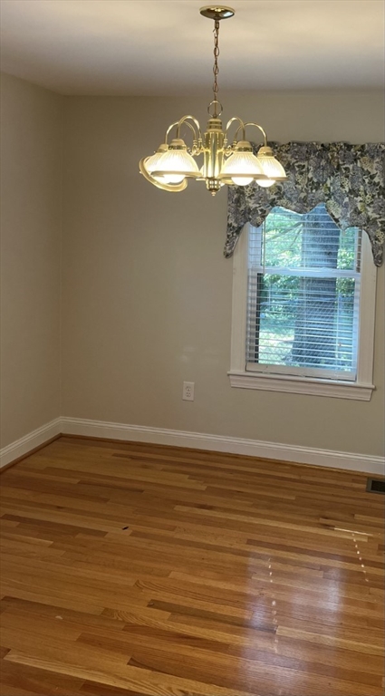 21 Grove Street Saugus, MA 01906 - Photo 10 of 10 a view of a livingroom with a chandelier wooden floor chandelier and a kitchen view