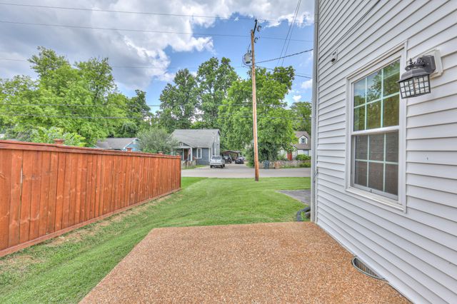a view of backyard with table and chairs and potted plants