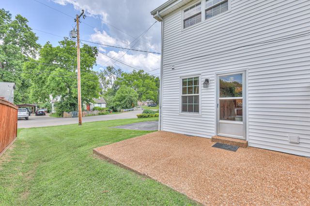 a view of a house with backyard and a tree