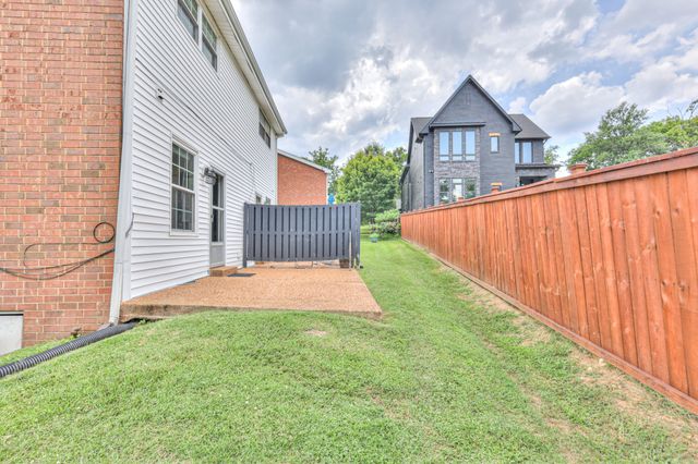 a view of a house with a yard and pathway