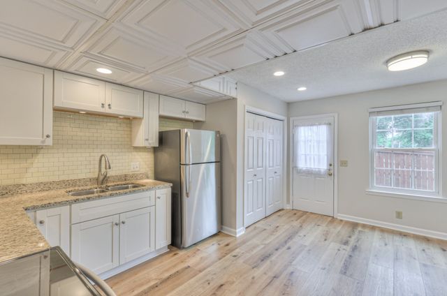 a kitchen with refrigerator cabinets and wooden floor