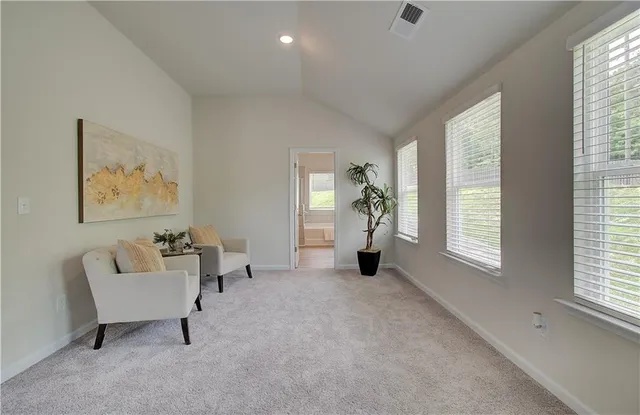 a spacious bedroom with a bed a table and a chandelier
