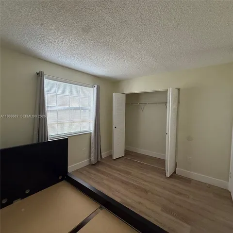 an empty room with wooden floor and door