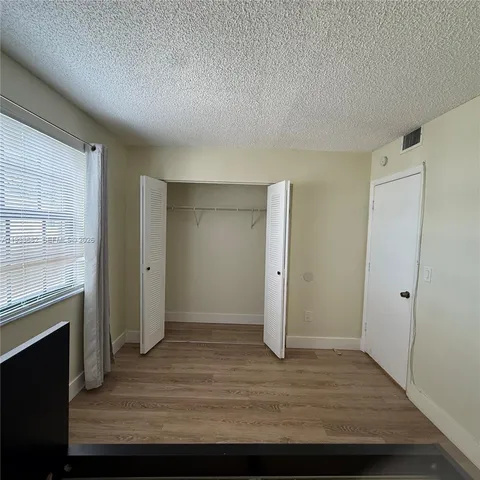 an empty room with wooden floor and a window