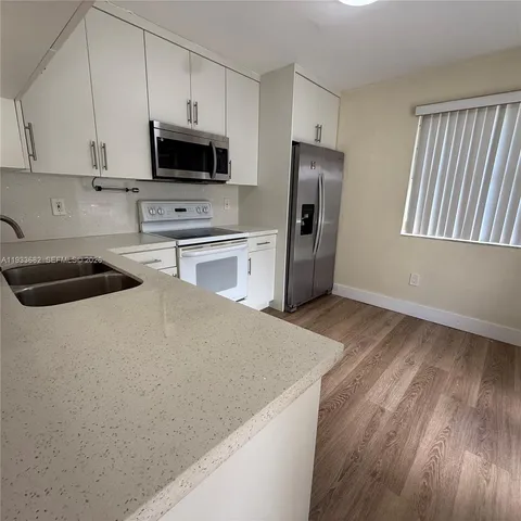 a view of an empty room with wooden floor and closet