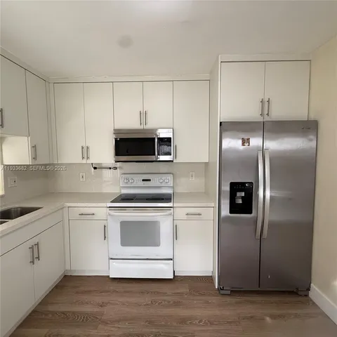 a bathroom with a granite countertop sink a large mirror and a bathtub