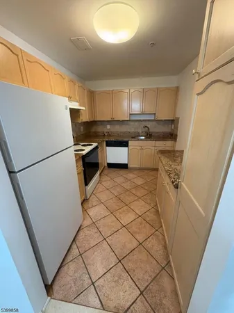 a kitchen with a refrigerator a stove top oven and a sink