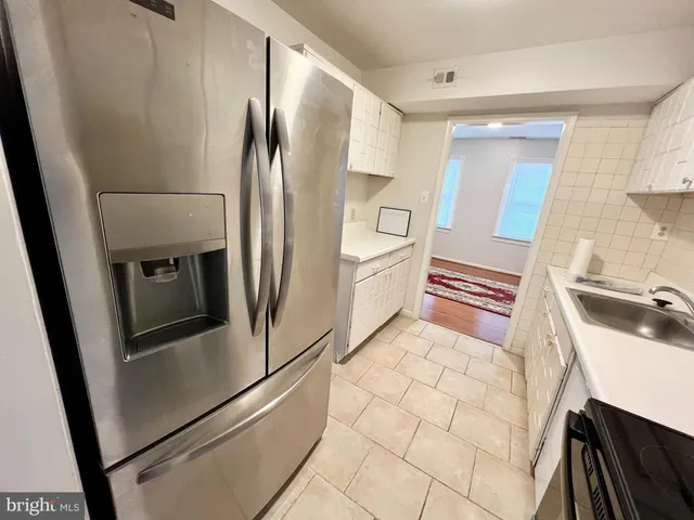 a kitchen with a sink a refrigerator and cabinets
