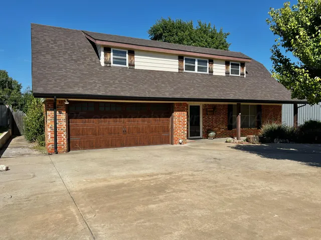 a front view of a house with yard and garage