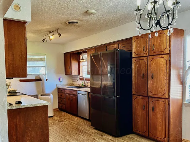 a kitchen with stainless steel appliances granite countertop a refrigerator a sink and dishwasher