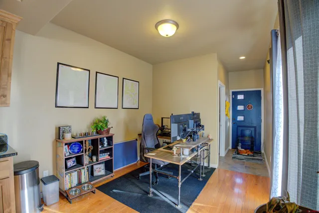 a living room with furniture and a dining table with bookshelf