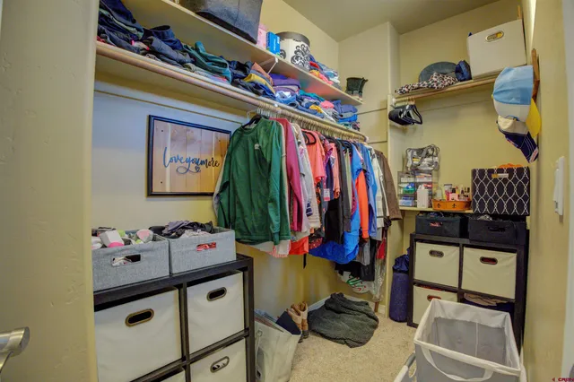 a view of walk in closet with clothes and shoes