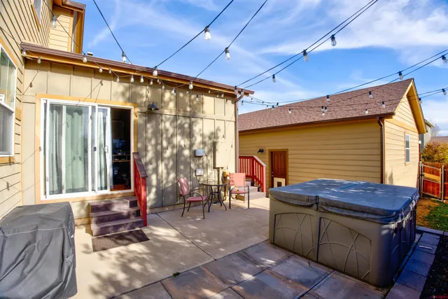 a backyard of a house with barbeque oven table and chairs