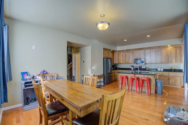 a kitchen with stainless steel appliances granite countertop a dining table chairs sink and stove