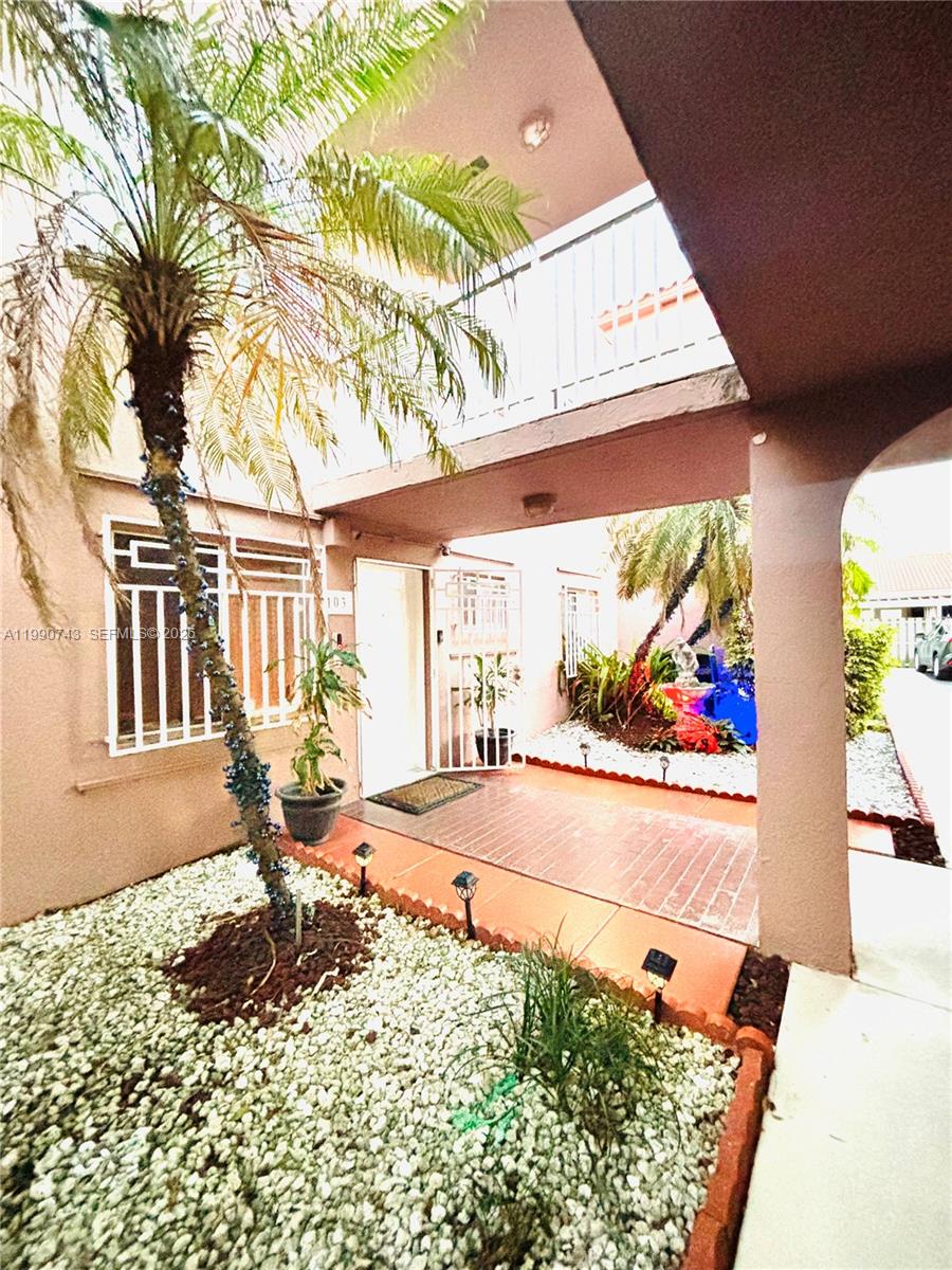 2310 West 74th Street, Unit 103 Hialeah, FL 33016 - Photo 1 of 18 a view of a porch with a floor to ceiling window next to a yard