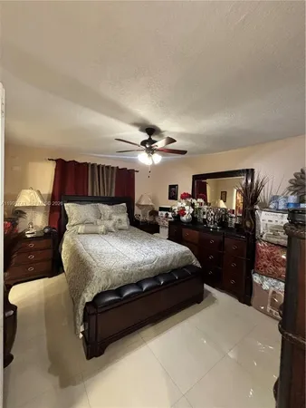 a spacious bedroom with a bed and ceiling fan