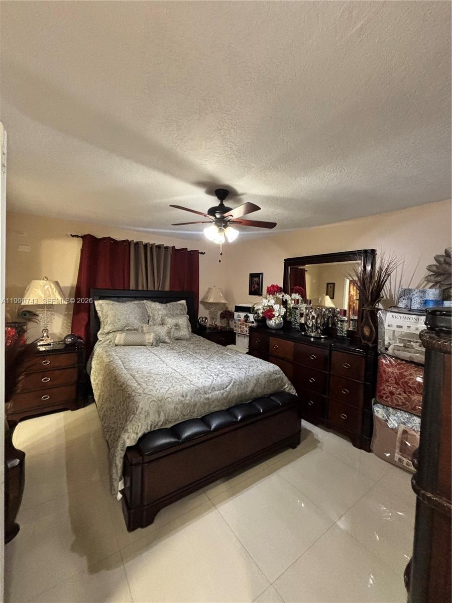 2310 West 74th Street, Unit 103 Hialeah, FL 33016 - Photo 13 of 18 a spacious bedroom with a bed and ceiling fan