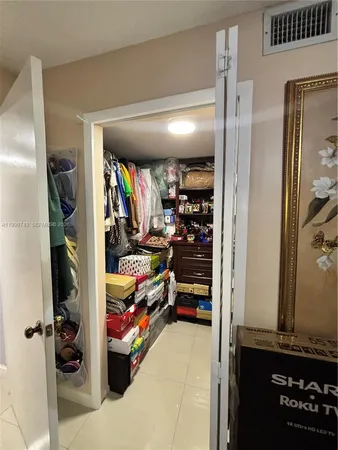 a view of walk in closet with clothes and shoes