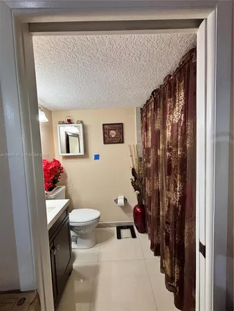 a bathroom with a toilet sink and shower curtain