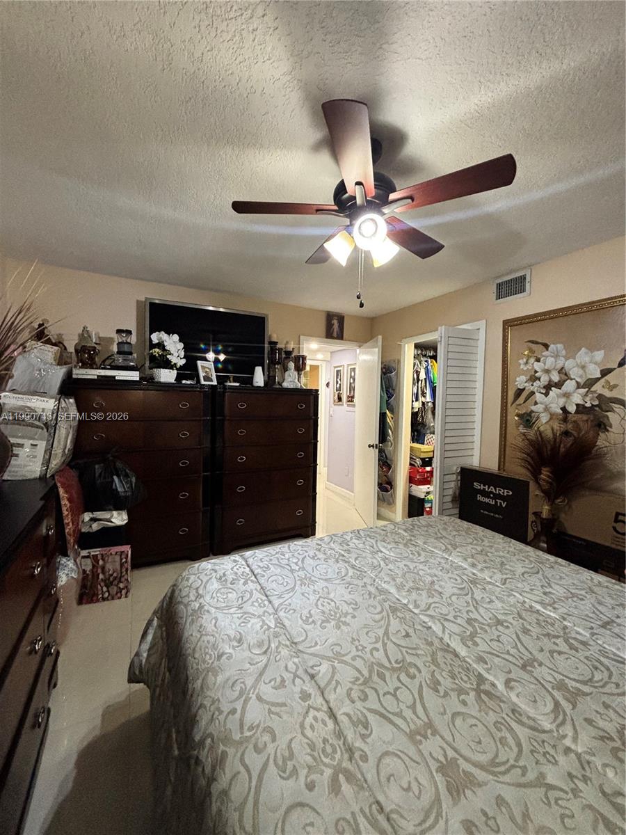 2310 West 74th Street, Unit 103 Hialeah, FL 33016 - Photo 17 of 18 a bedroom with a bed and a chandelier