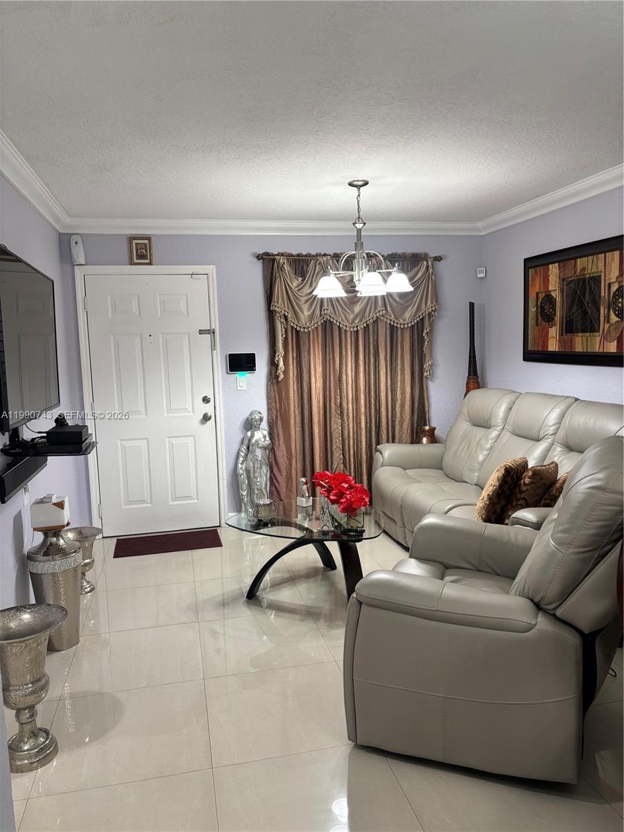 2310 West 74th Street, Unit 103 Hialeah, FL 33016 - Photo 4 of 18 a living room with furniture a chandelier and a flat screen tv
