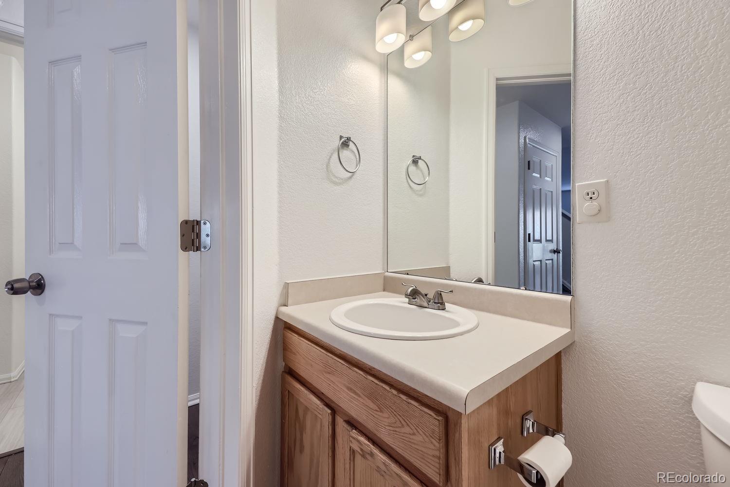 4512 Cornish Way Denver, CO 80239 - Photo 14 of 35 a bathroom with a sink and a mirror with toilet
