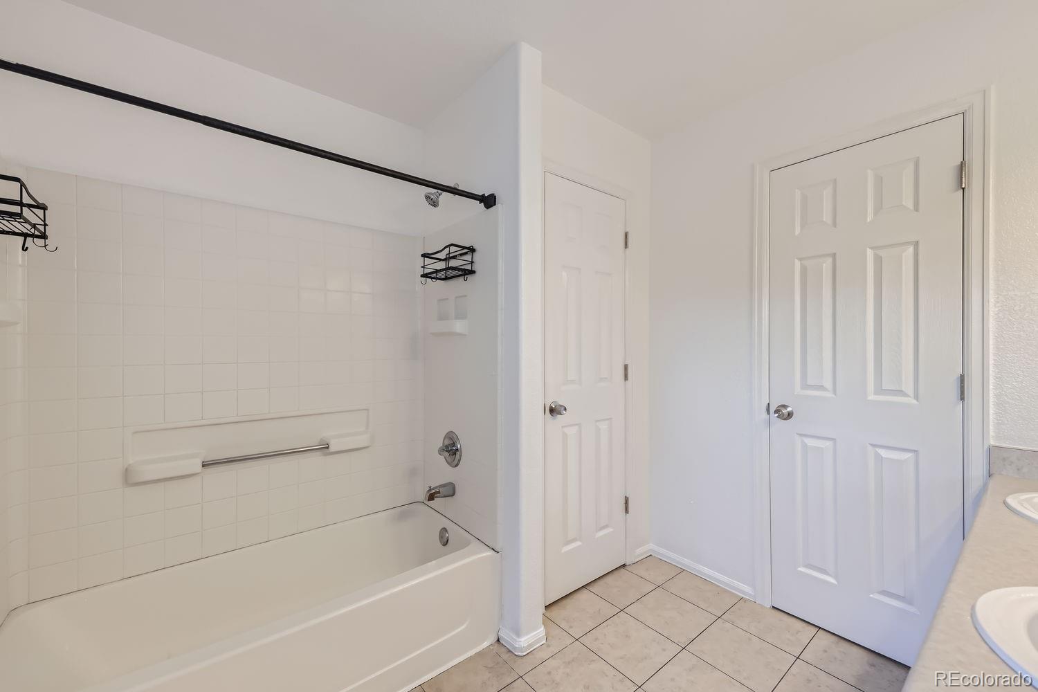 4512 Cornish Way Denver, CO 80239 - Photo 17 of 35 a bathroom with a bathtub and a shower