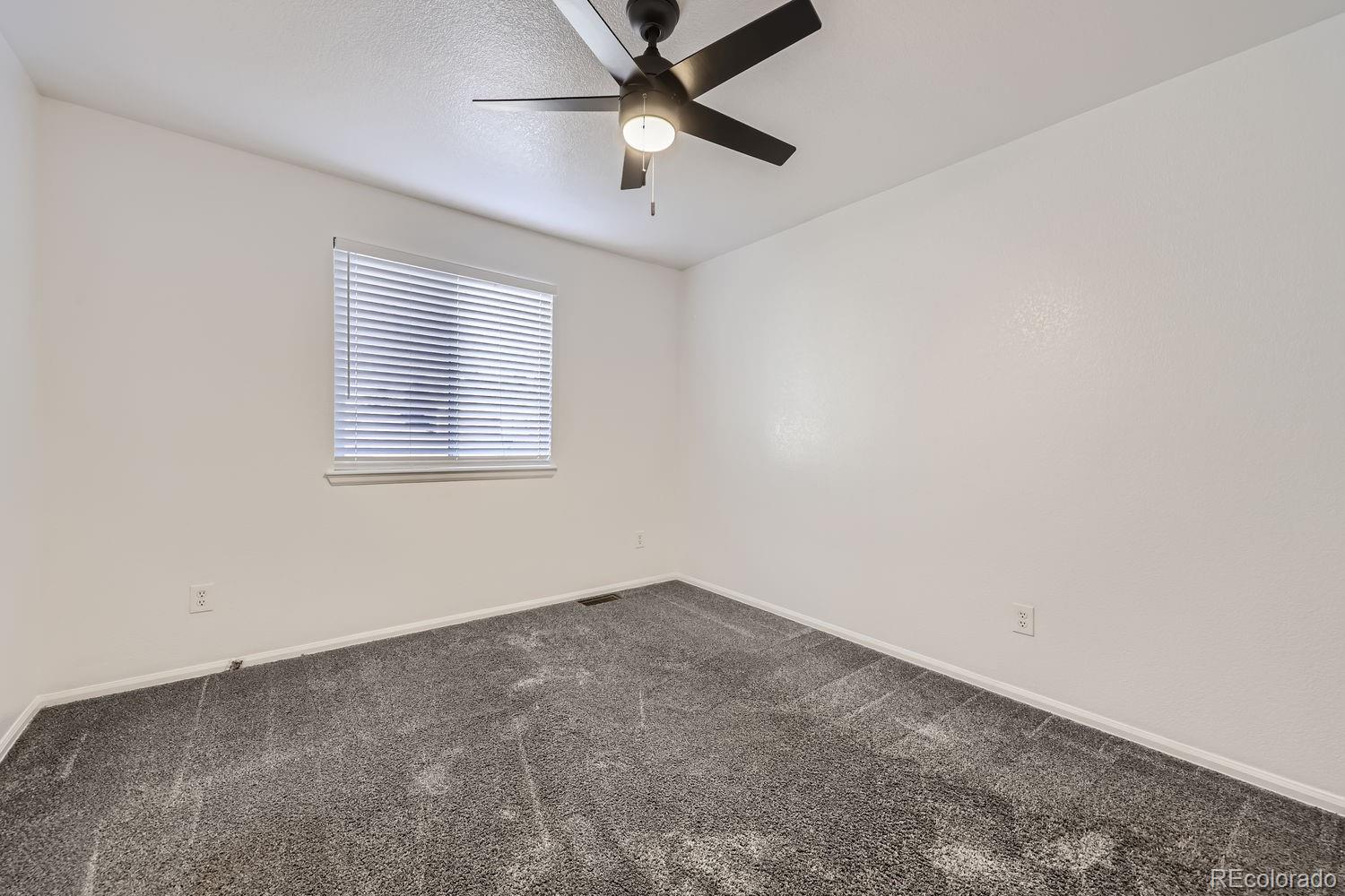 4512 Cornish Way Denver, CO 80239 - Photo 19 of 35 an empty room with a window and a fan