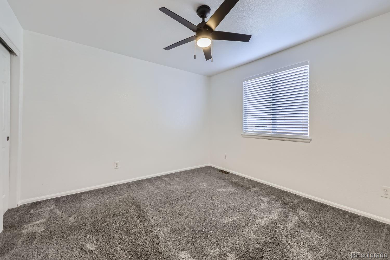 4512 Cornish Way Denver, CO 80239 - Photo 21 of 35 an empty room with a window and a ceiling fan