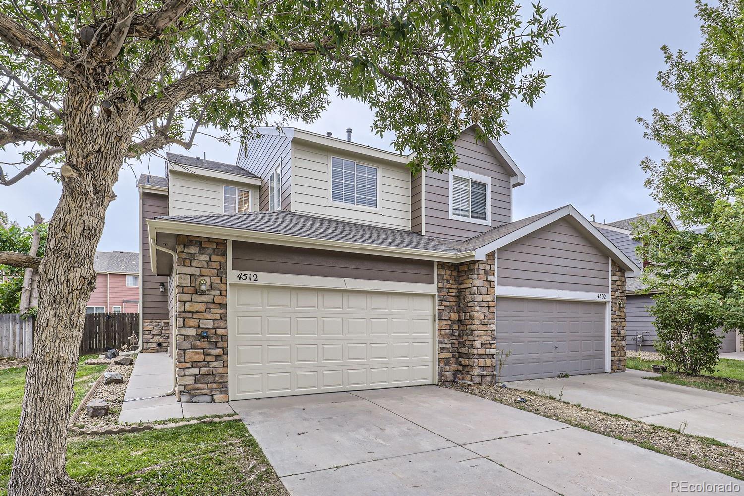 4512 Cornish Way Denver, CO 80239 - Photo 3 of 35 a front view of a house with a garage
