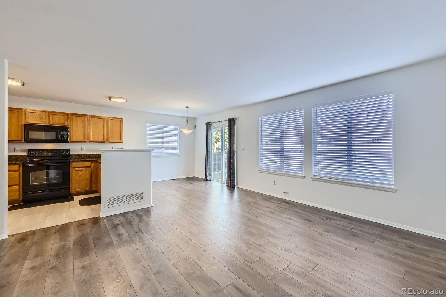 4512 Cornish Way Denver, CO 80239 - Photo 6 of 35 a view of a kitchen with a stove cabinets and wooden floor