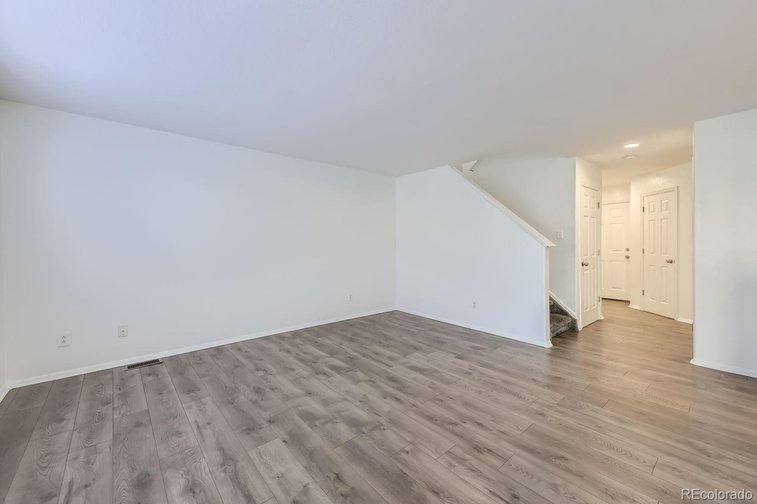 4512 Cornish Way Denver, CO 80239 - Photo 7 of 35 a view of an empty room with wooden floor