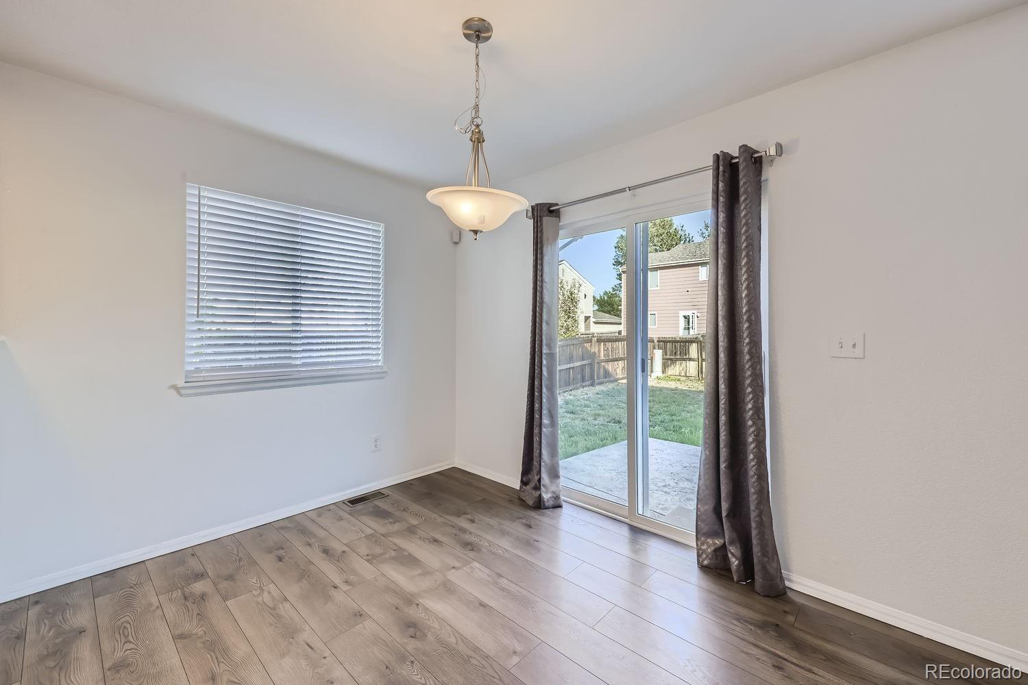 4512 Cornish Way Denver, CO 80239 - Photo 8 of 35 a view of an empty room with wooden floor and a window