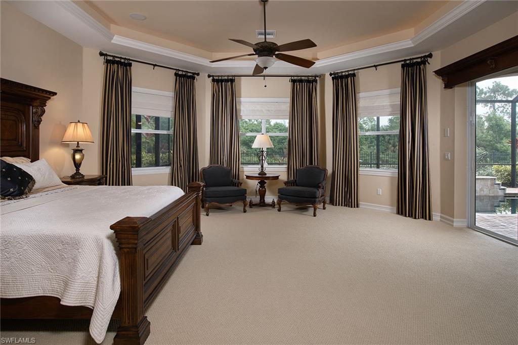 419 Saddlebrook Lane Naples, FL 34110 - Photo 11 of 24 a bed room with a bed and a chandelier