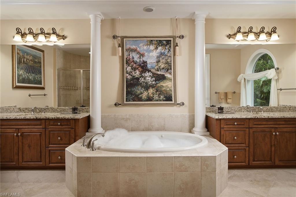 419 Saddlebrook Lane Naples, FL 34110 - Photo 13 of 24 a spacious bathroom with a granite countertop tub sink and mirror