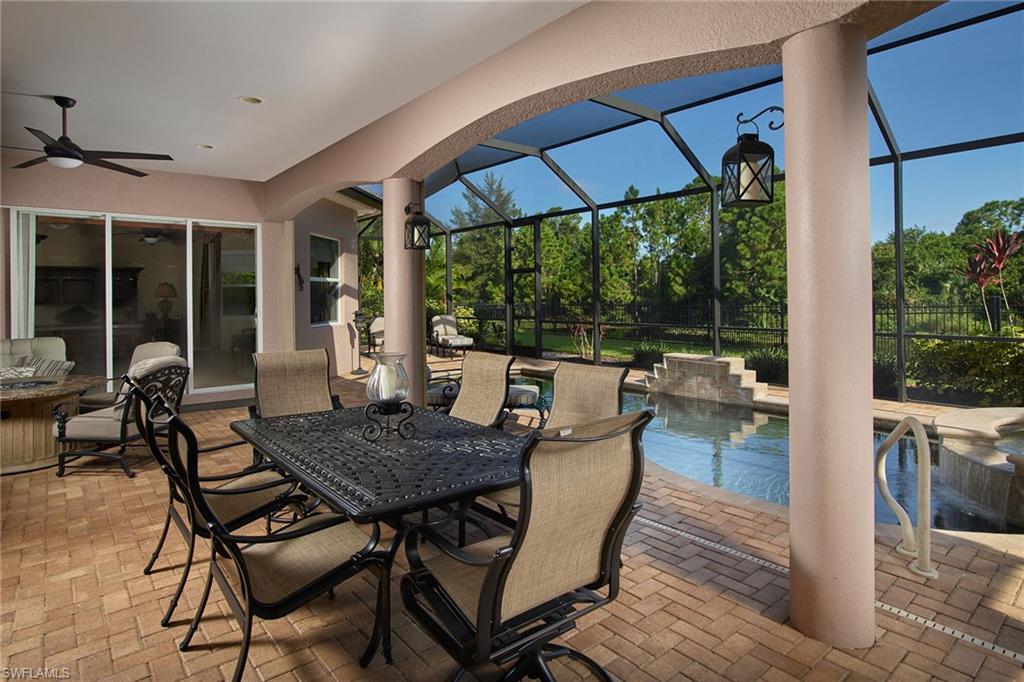 419 Saddlebrook Lane Naples, FL 34110 - Photo 19 of 24 a view of a patio with a table and chairs under an umbrella