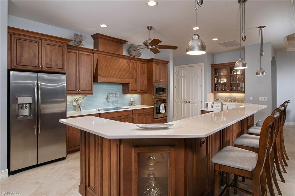419 Saddlebrook Lane Naples, FL 34110 - Photo 7 of 24 a kitchen with a table chairs refrigerator and microwave