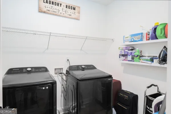 a utility room with dryer washer and other items