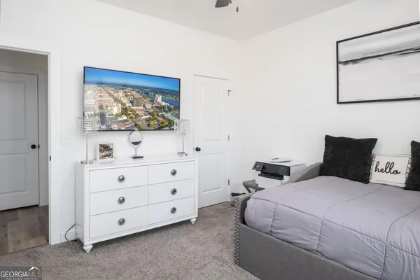 a bedroom with a bed and a painting on the wall