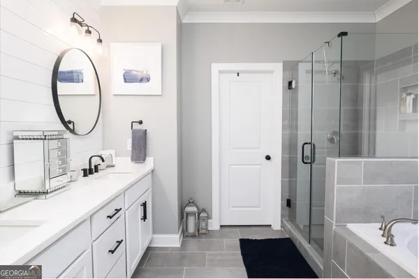 a en suite bathroom with a tub sink and mirror