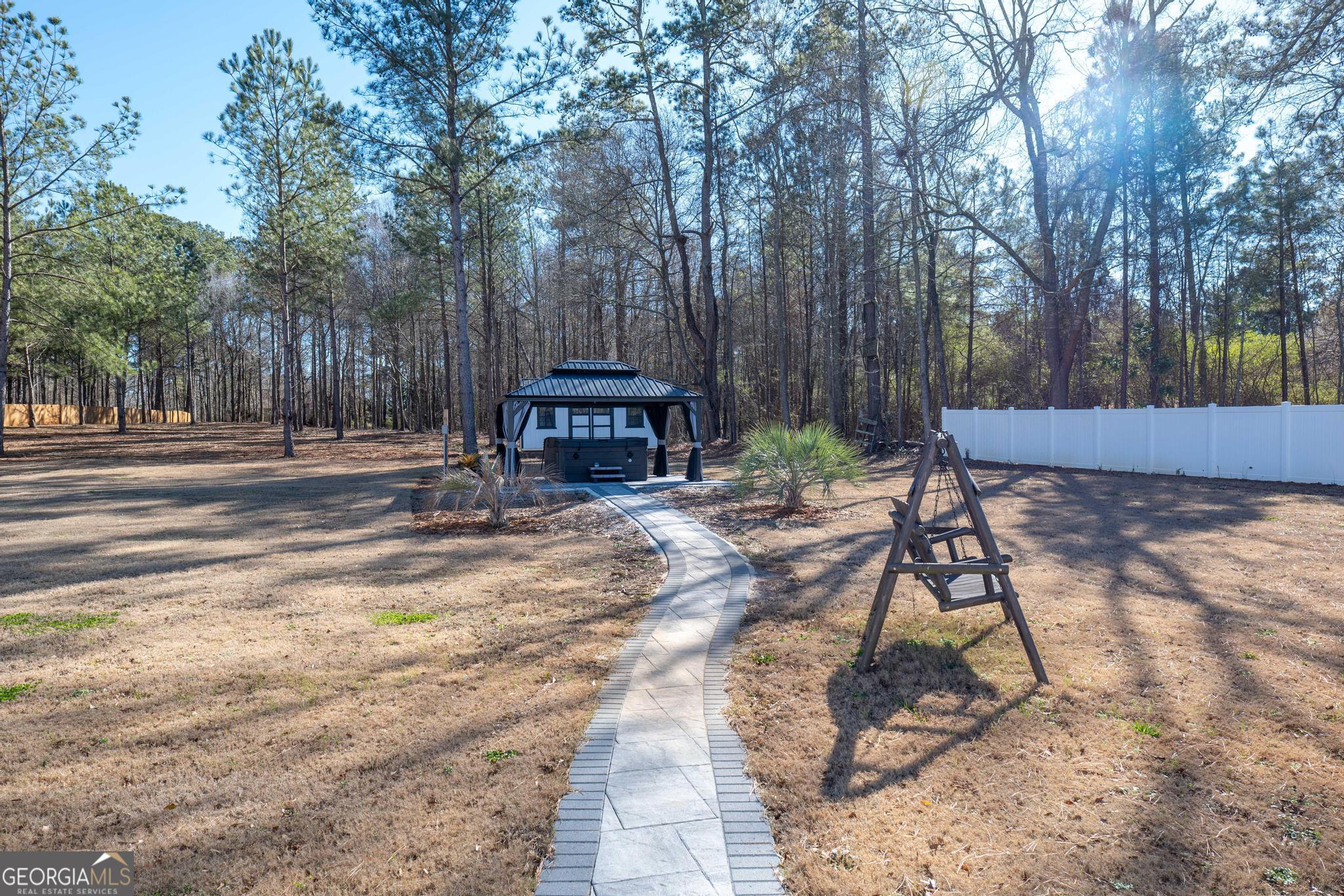 1016 Farmington Road Griffin, GA 30224 - Photo 28 of 31 a wooden bench sitting in the middle of a yard