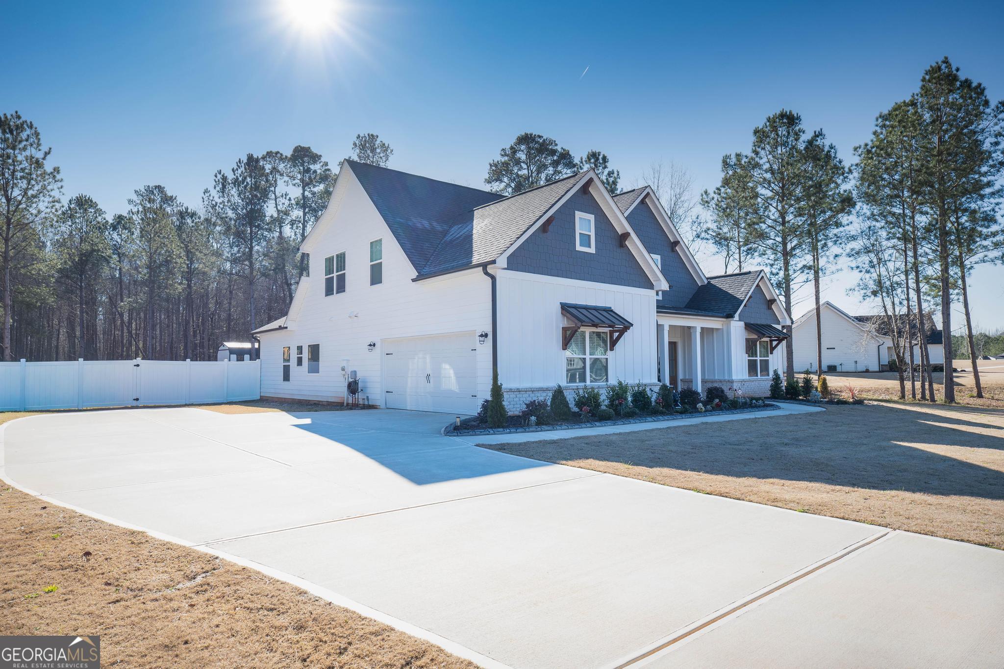 1016 Farmington Road Griffin, GA 30224 - Photo 4 of 31 a view of a white house next to a yard with road and trees