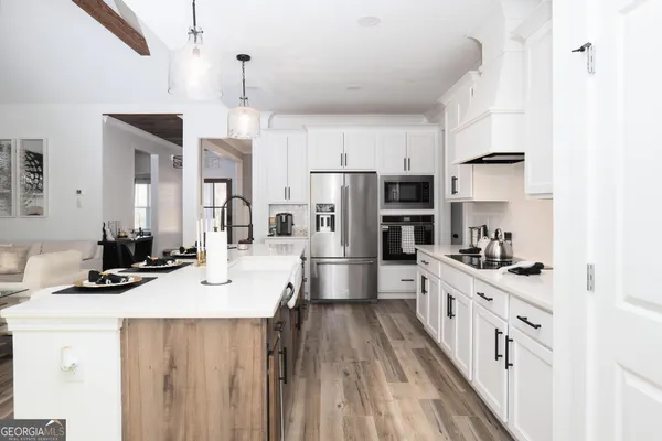 a kitchen with refrigerator a stove and a wooden floor