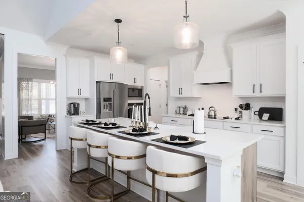 a kitchen with stainless steel appliances a stove a sink a stove a refrigerator and white cabinets