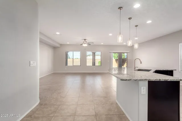 a view of an empty room and kitchen view