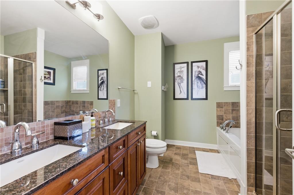 117 South Bay Road, Unit 402 Eatonton, GA 31024 - Photo 21 of 48 a bathroom with double vanity sinks a toilet a mirror and shower