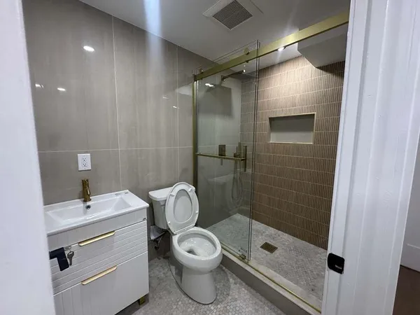 a bathroom with a granite countertop sink toilet and shower