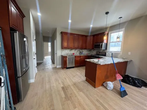 a kitchen with stainless steel appliances granite countertop a refrigerator a stove top oven a sink and dishwasher