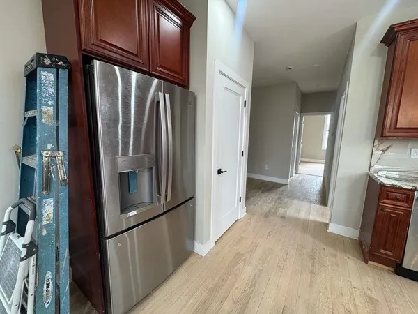 a view of a refrigerator and wooden floor