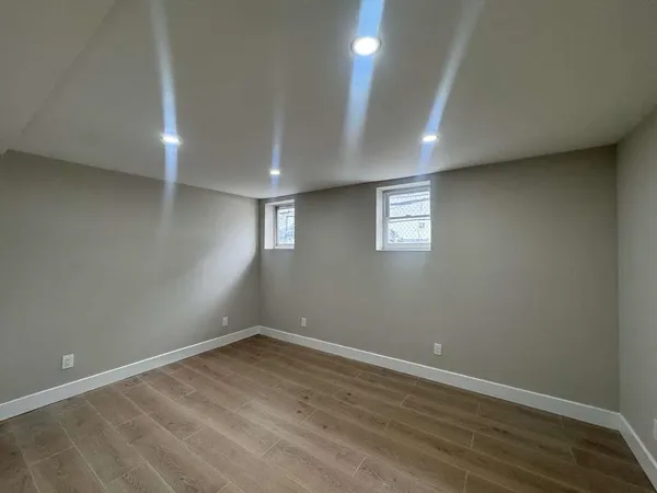 an empty room with wooden floor and window